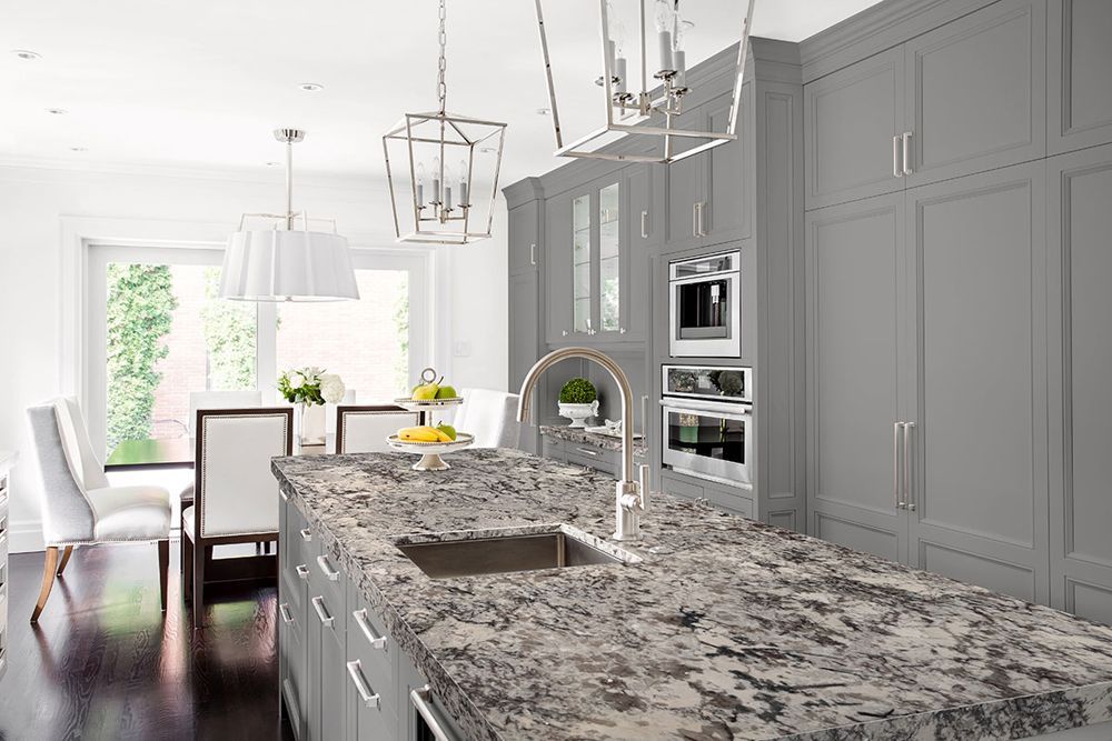 Modern white kitchen with gray cabinets, granite island, and stainless steel appliances