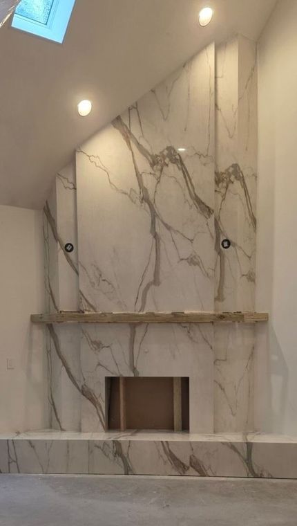 Marble-clad fireplace wall with built-in niche and spotlights in a modern room