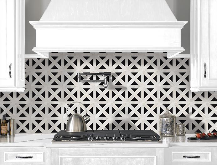 White kitchen stove and hood with patterned black-and-white tile backsplash and white cabinets