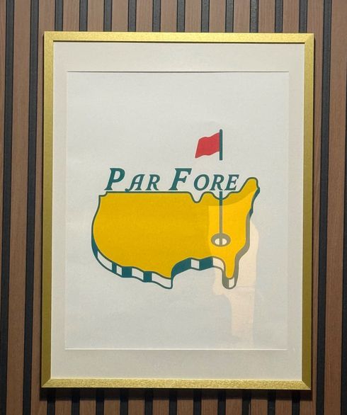 Person on golf course surrounded by golf balls and club, wearing a white hat.