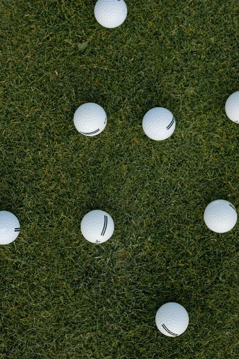 Golf balls scattered on green grass.