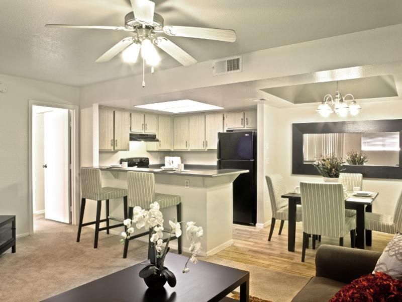 A living room with a ceiling fan and a table and chairs