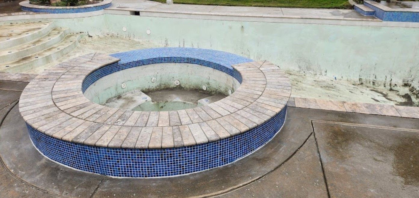 There is a hot tub in the middle of a swimming pool.