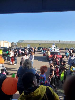 A group of people are standing in a parking lot.