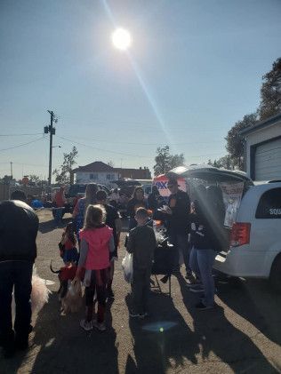 A group of people are standing in front of a white van.