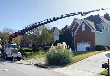 Crane truck extending over a residential neighborhood.