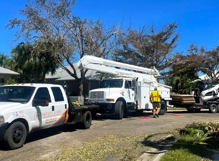 Utility trucks and crew working on power lines after a storm.