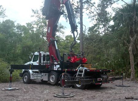 Stone steps lead up a lush garden with a waterfall, trees, and a blue pot.