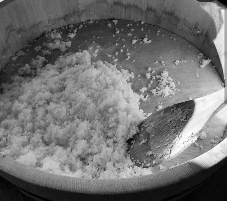 A bowl of rice with a wooden spoon in it.