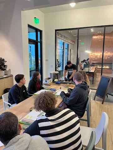 A group of people are sitting around a table in a room.