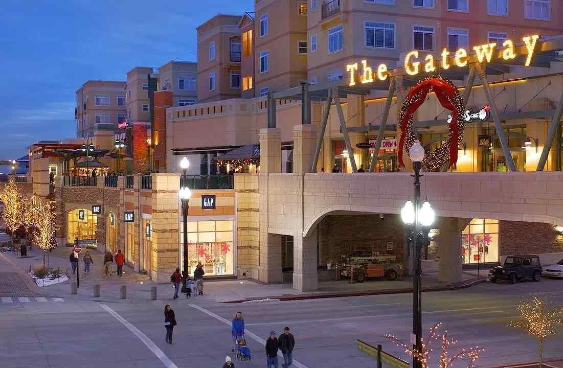 A group of people are walking in front of a building that says the gateway.