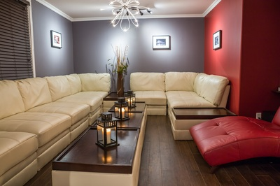 A long wooden table with teal chairs in a spacious cafe with pendant lights.