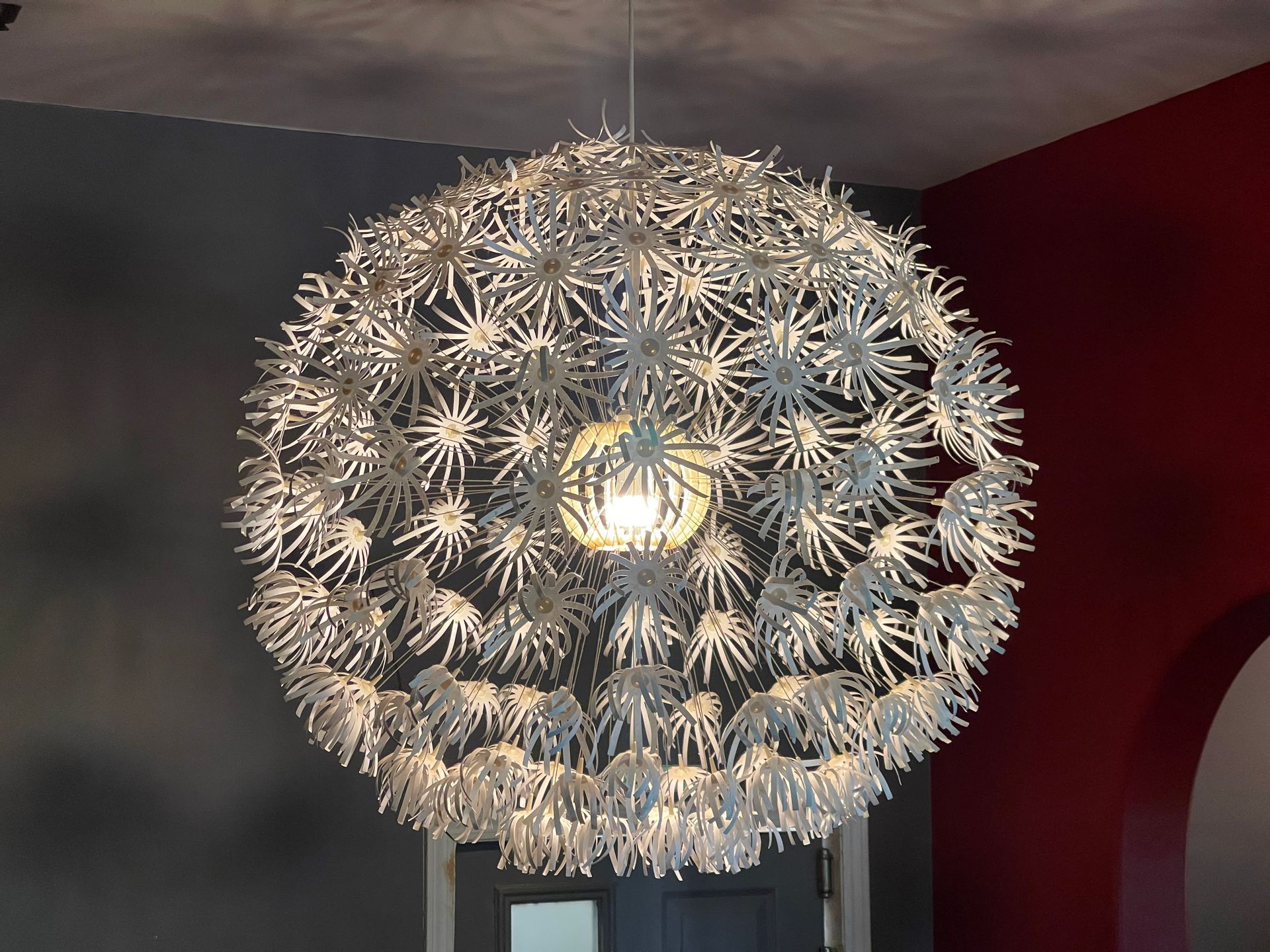 Outdoor lounge area with wooden furniture under a beige tent.