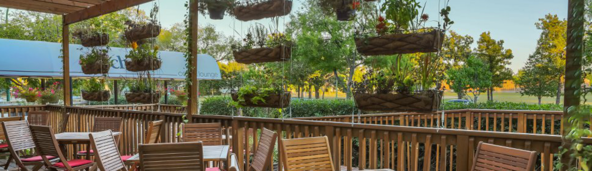 A cafe entrance with a small table and chairs in front. Doorway with chairs visible inside.