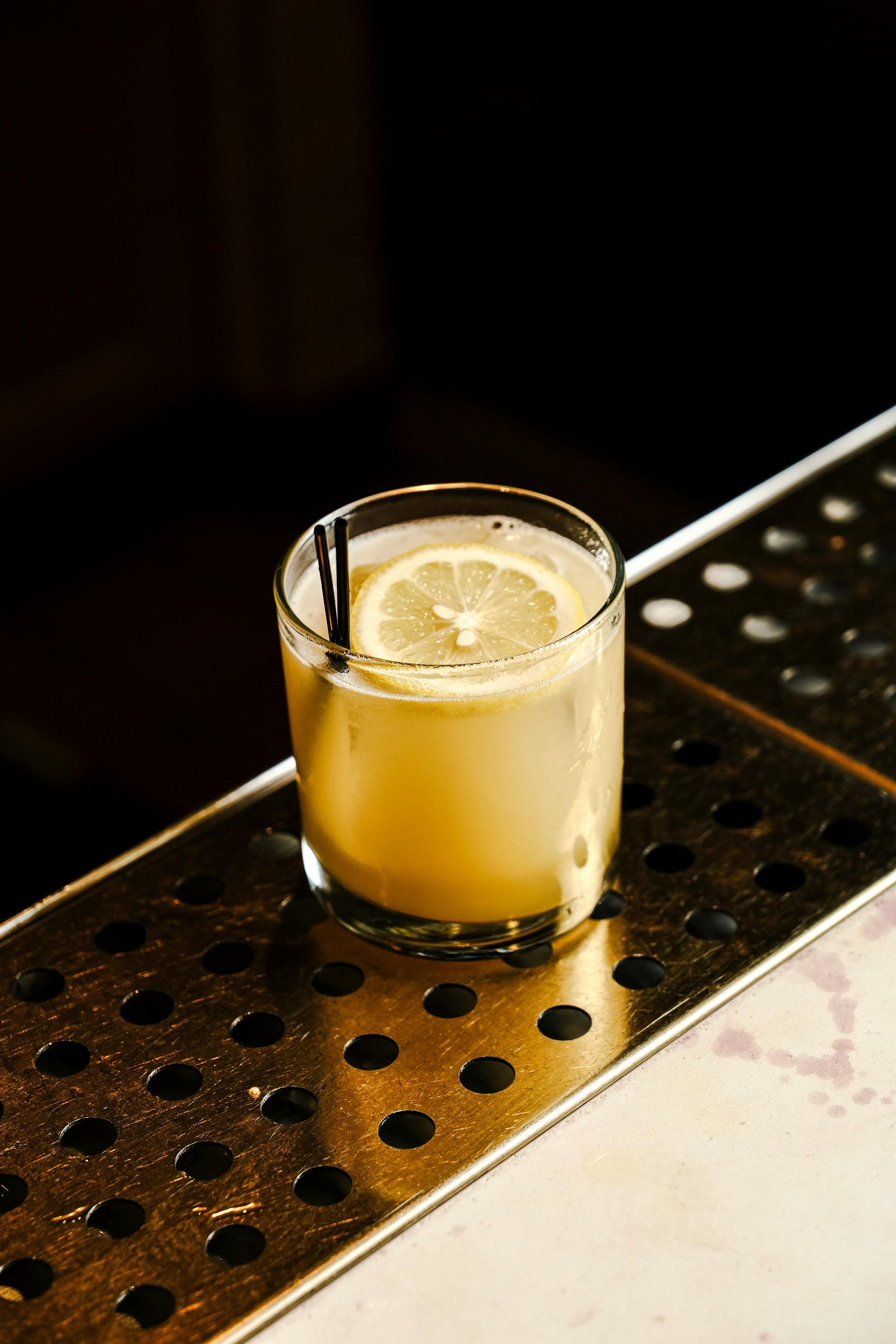 Wooden chairs and tables fill an empty restaurant with large windows.