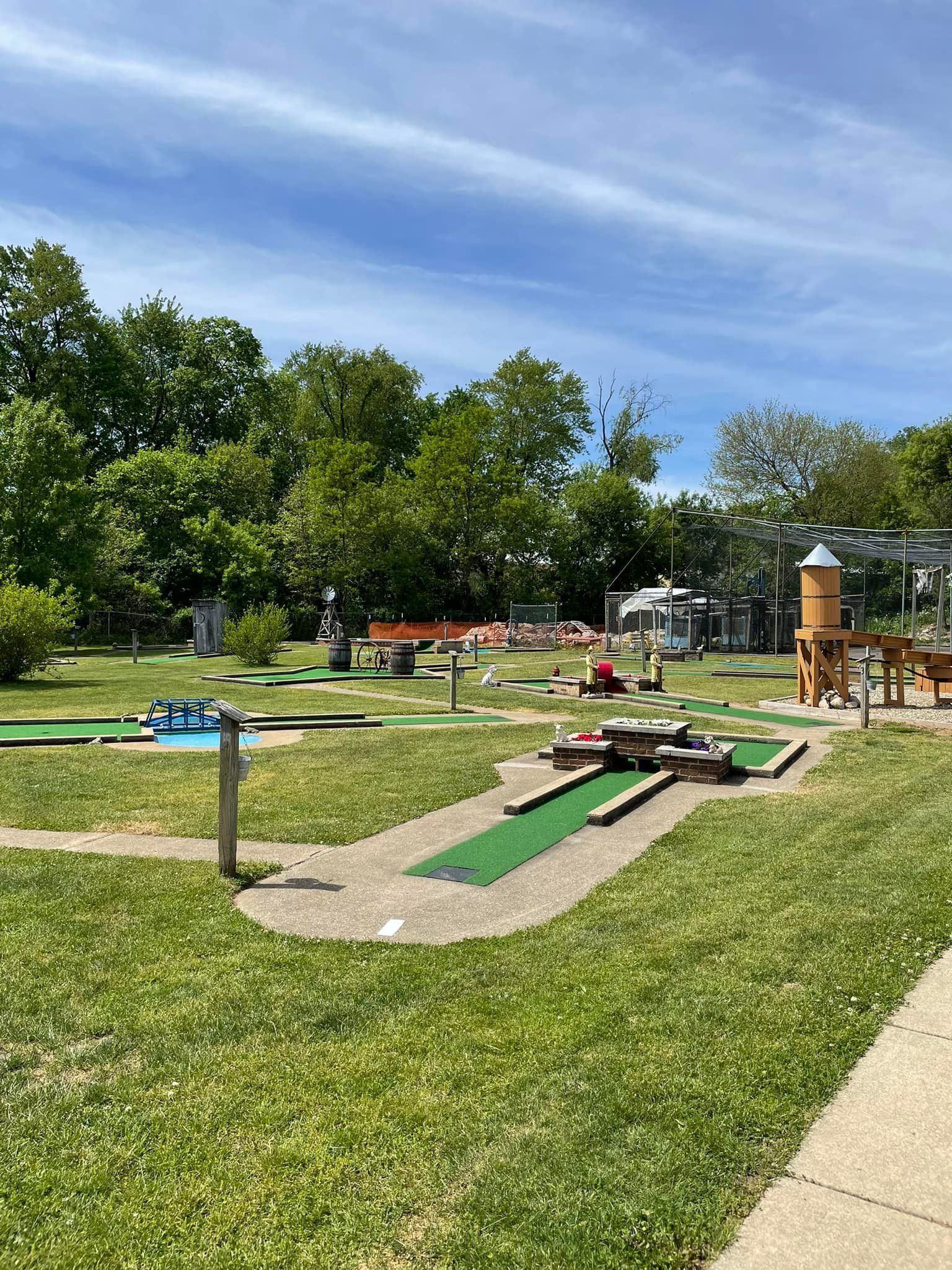 A mini golf course in a park on a sunny day.