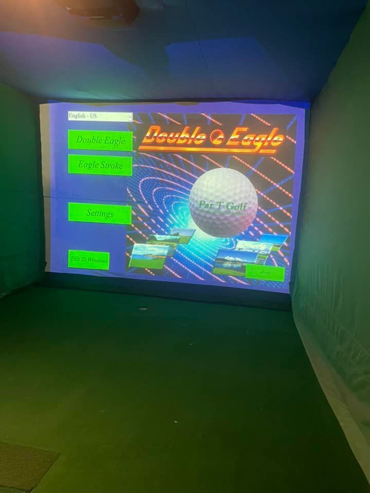 A golf ball is on a screen in a golf simulator.