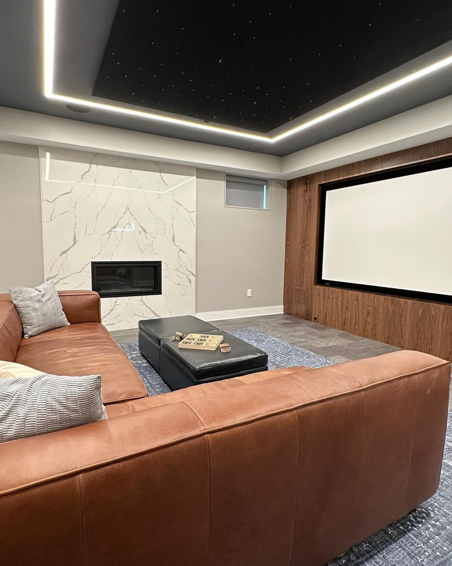 A living room with a couch and a projector screen.