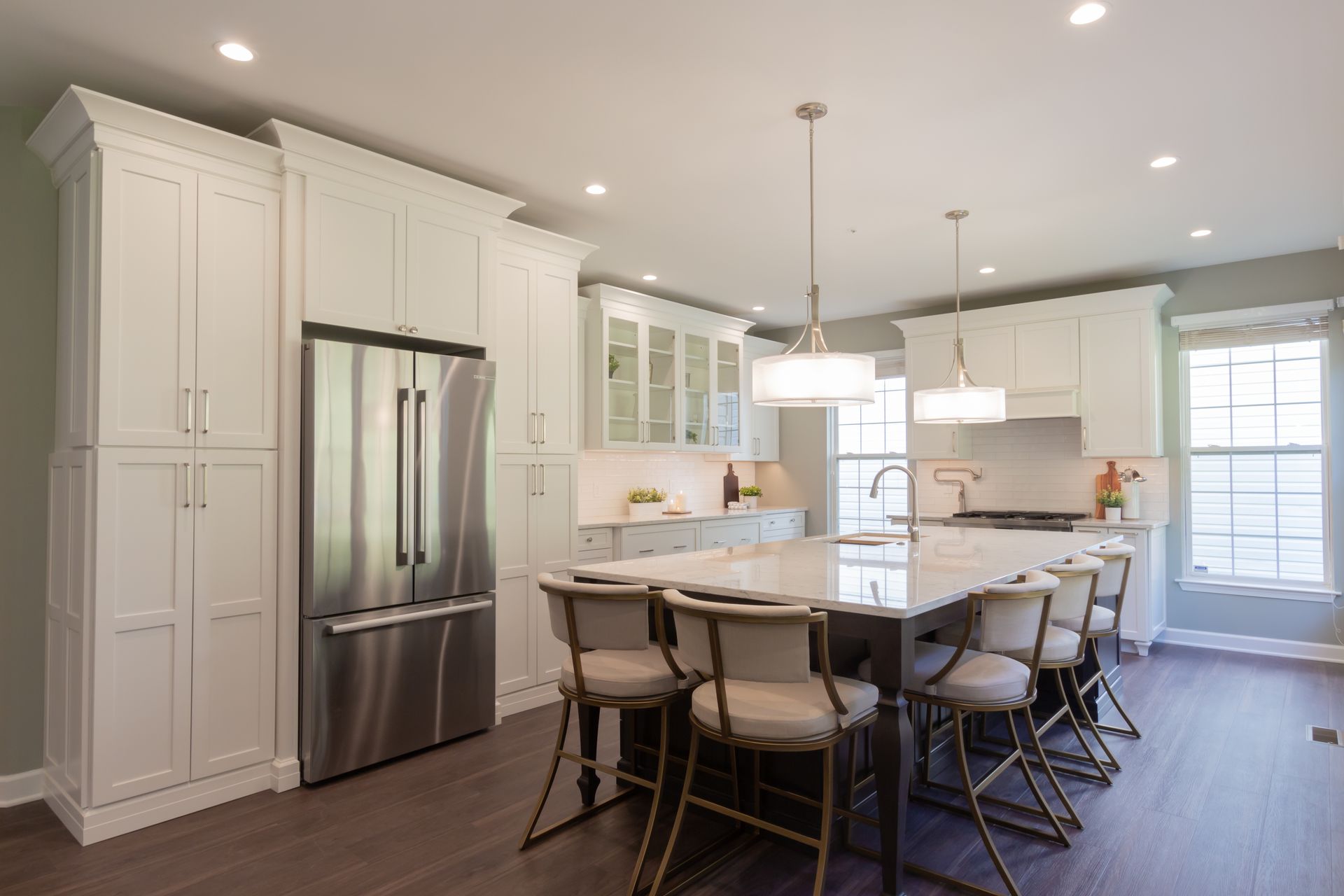 A kitchen with white cabinets and stainless steel appliances and a large island.