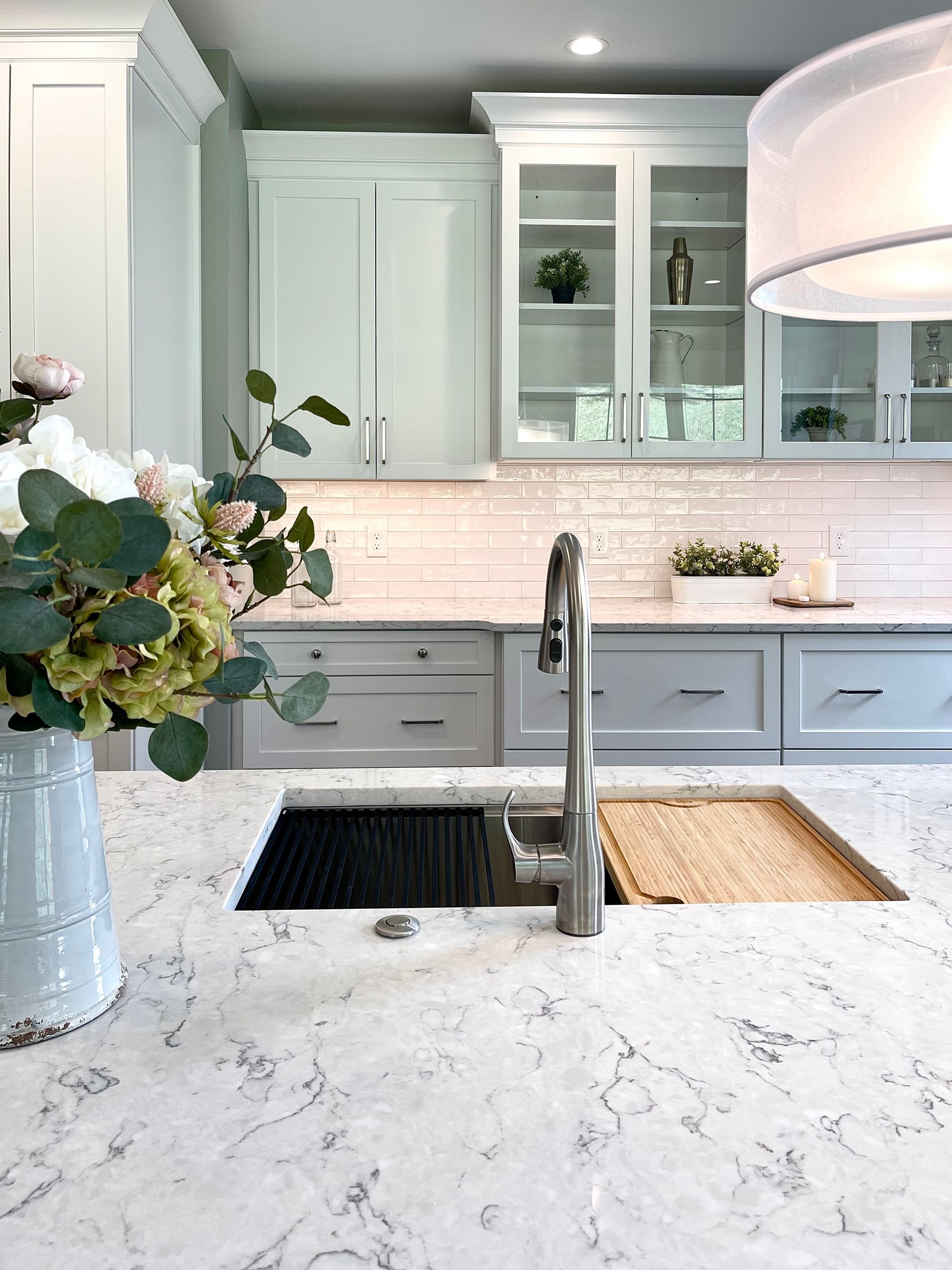 A kitchen with a sink and a vase of flowers on the counter.