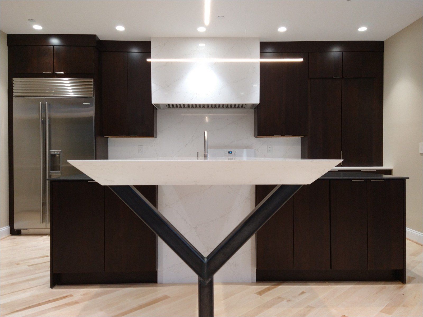 A kitchen with dark cabinets and a white counter top