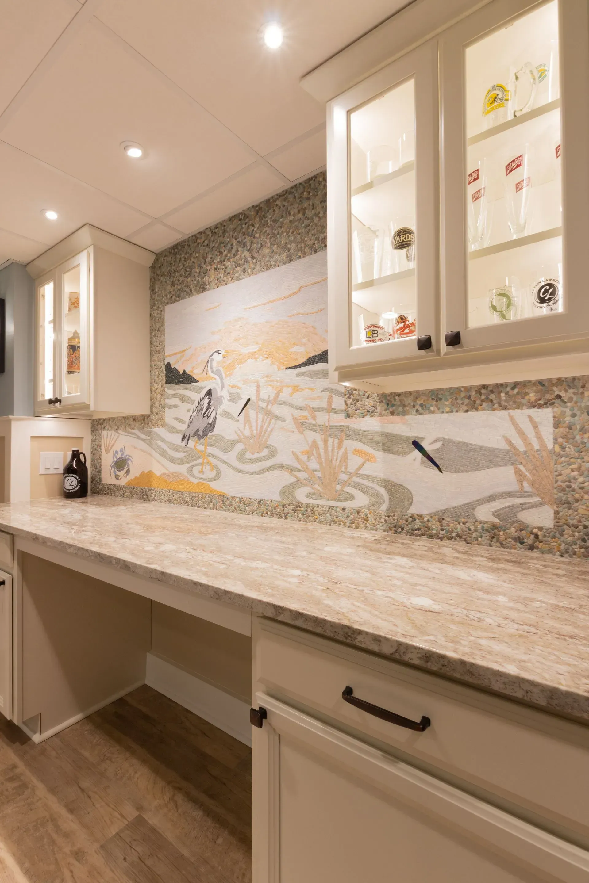 There is a painting on the wall above the counter in the kitchen.