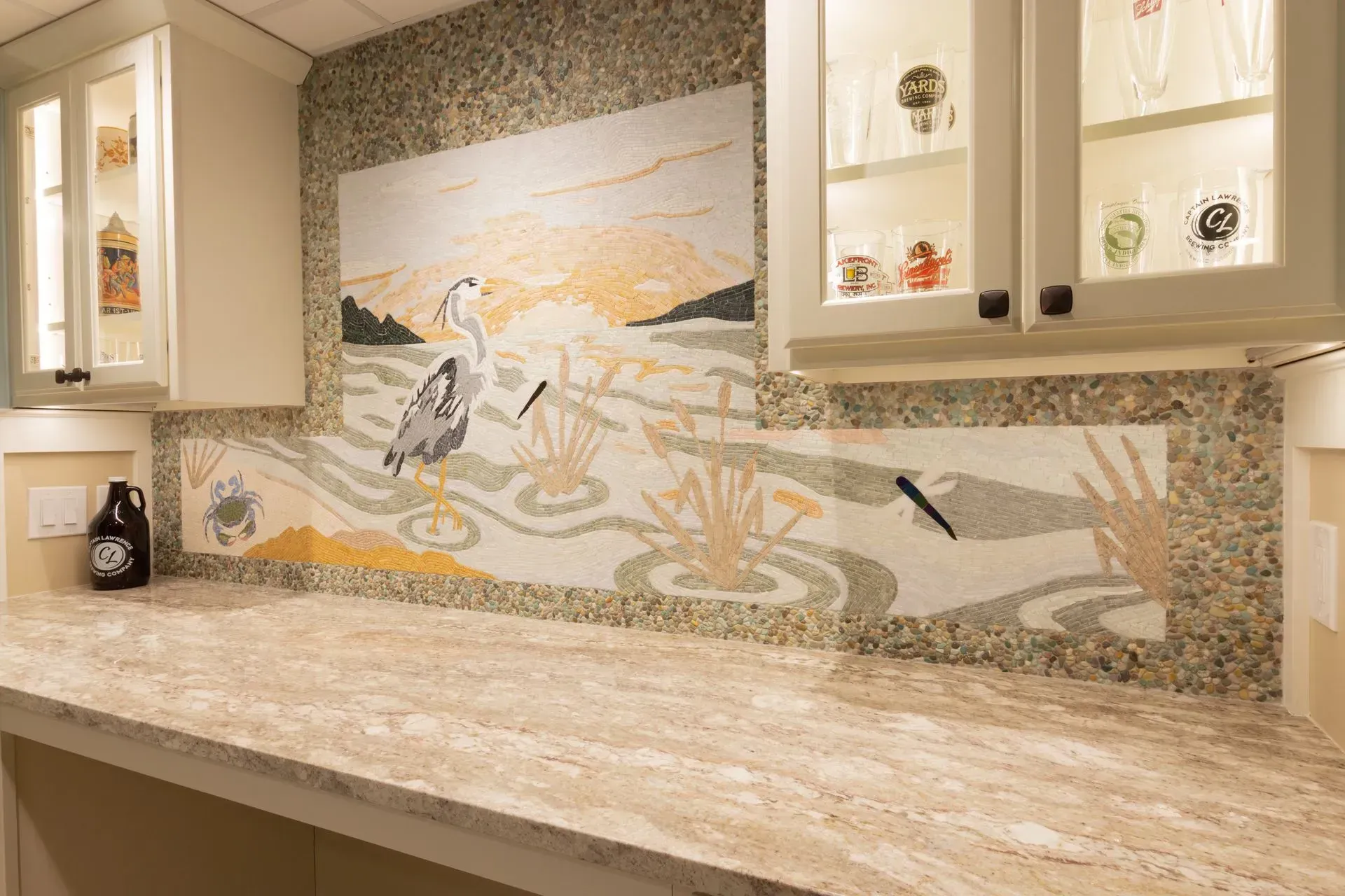 There is a painting on the wall above the counter in the kitchen.