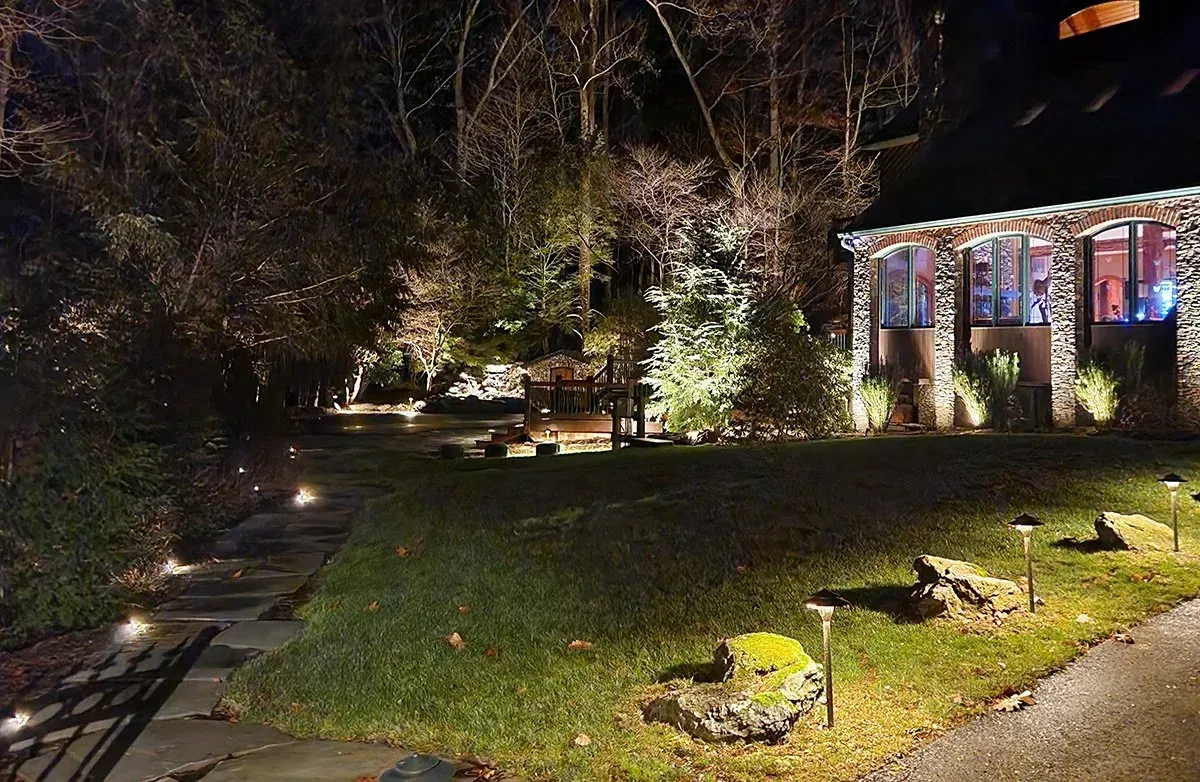 A house with christmas lights on it is lit up at night.