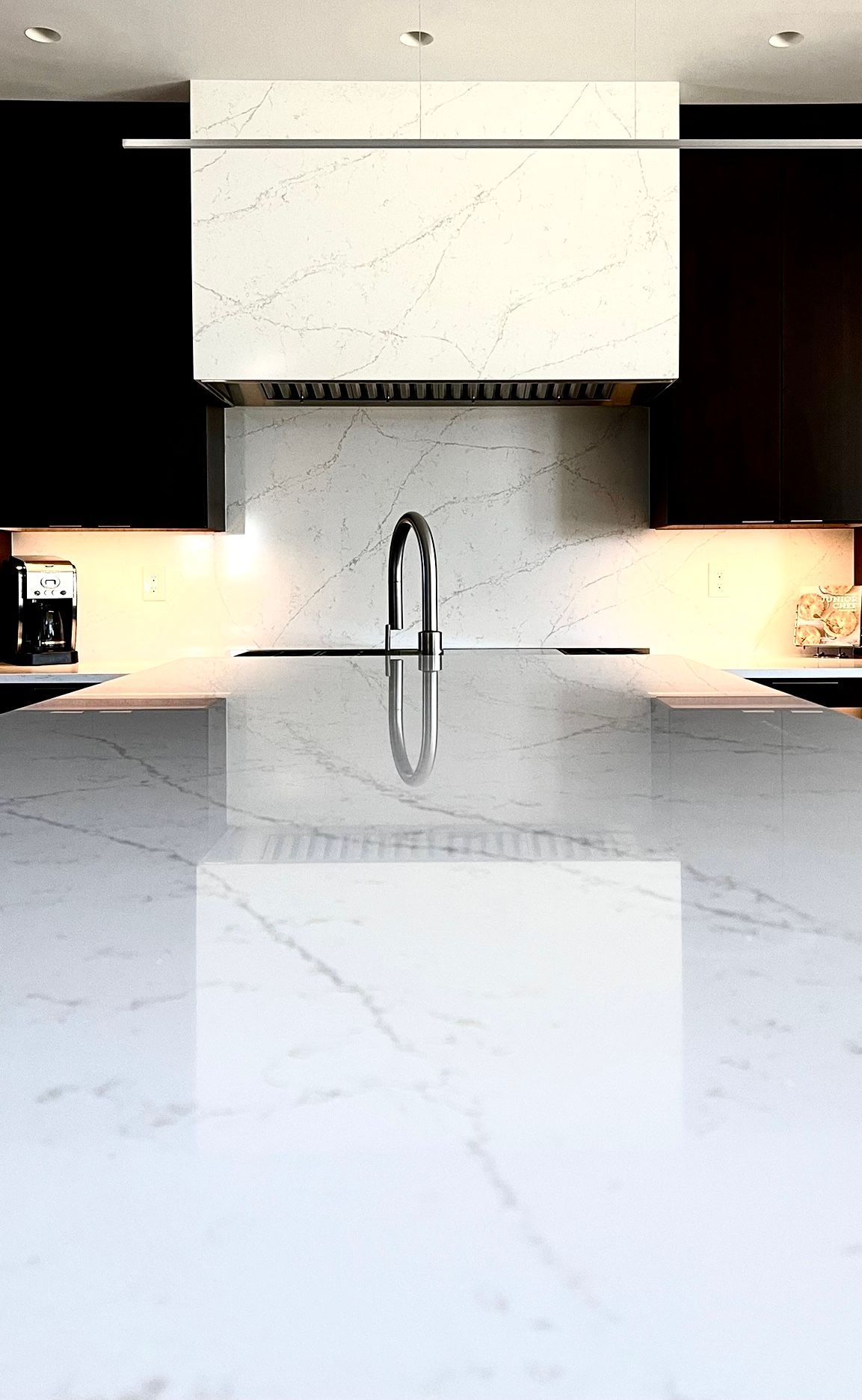 A kitchen with a white counter top and black cabinets