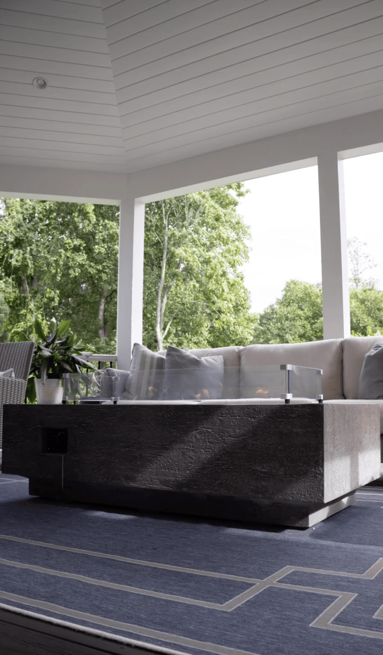 A living room with a couch and a table on a porch.