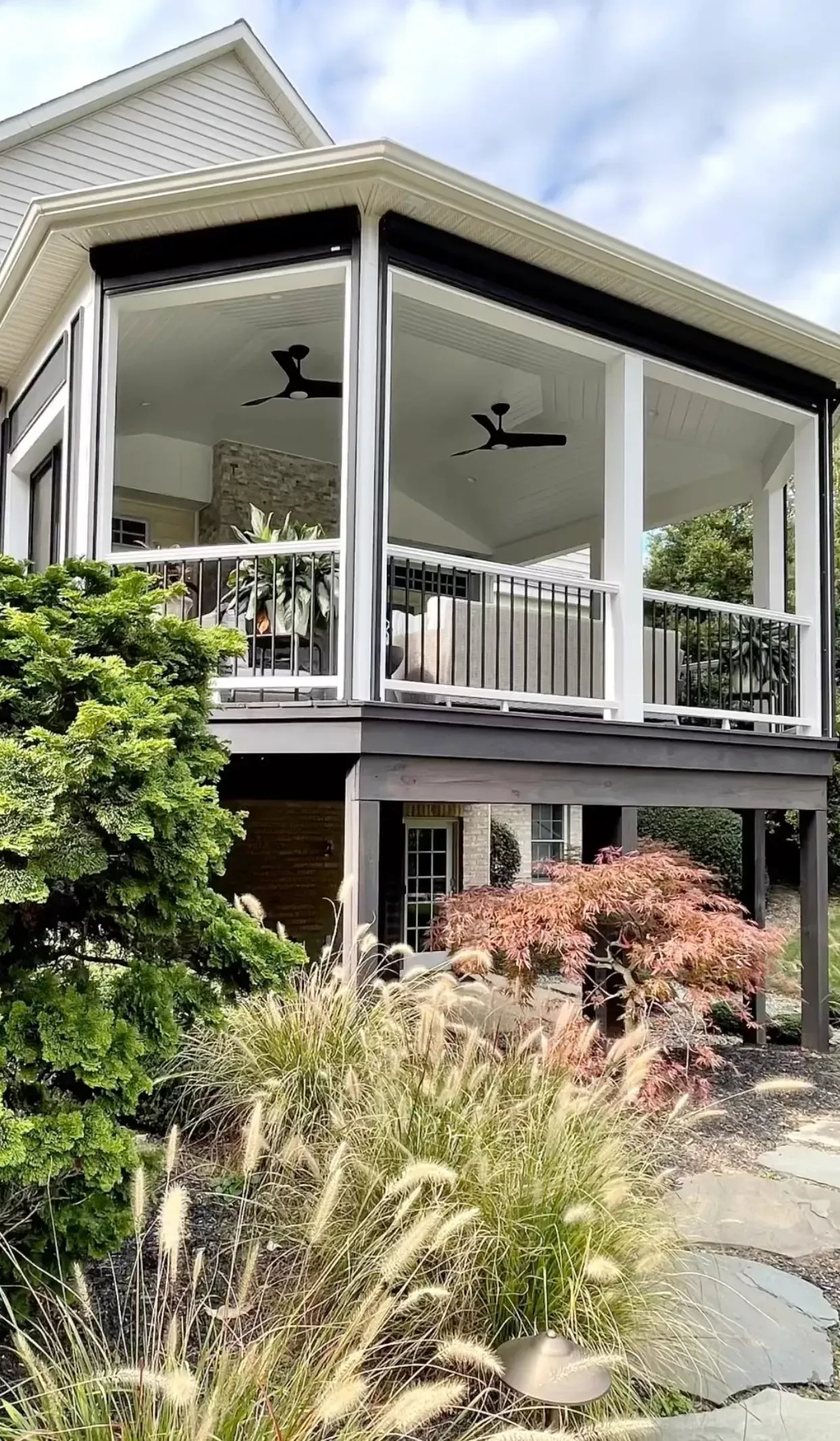 A large porch with a lot of windows and a ceiling fan.