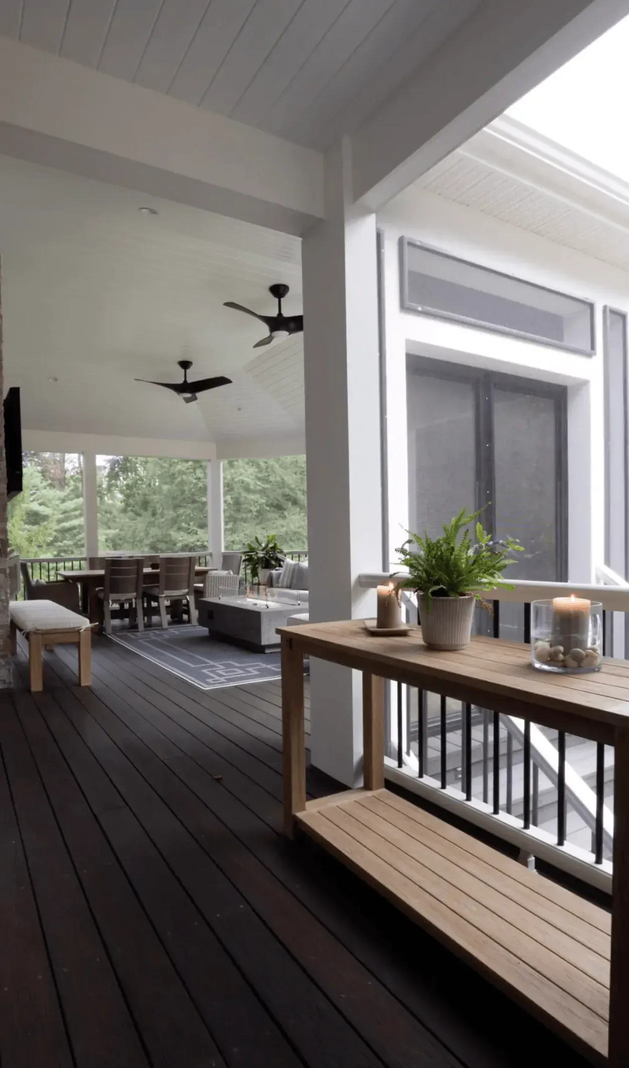 A screened in porch with a wooden table and a bench.