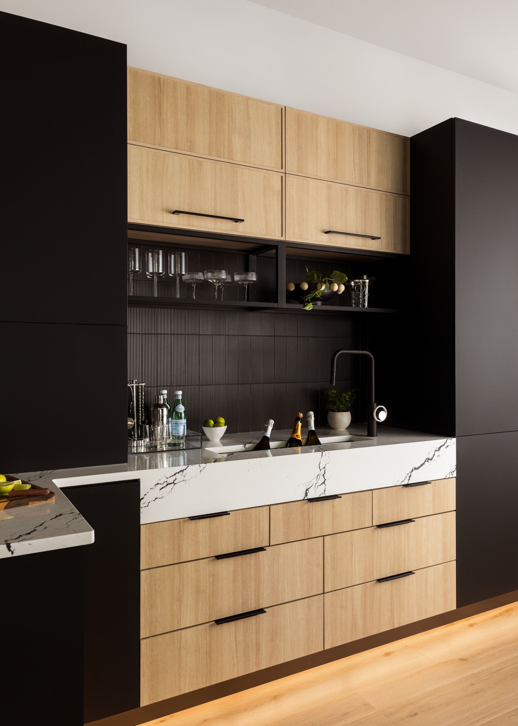 A kitchen with wooden cabinets and black walls
