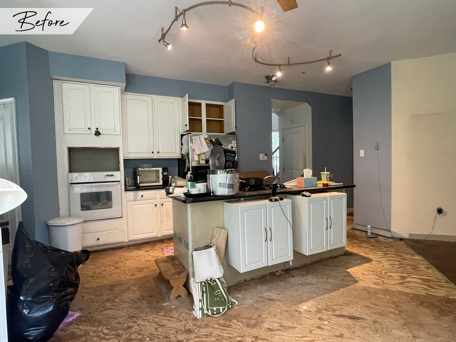 A kitchen with white cabinets and a large island in the middle of the room.