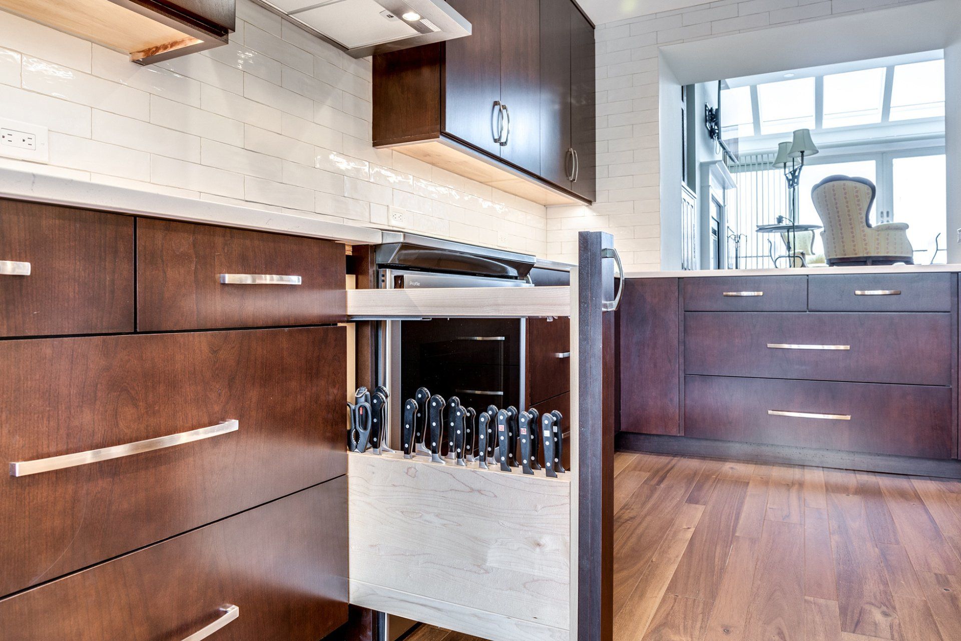 A kitchen with a pull out drawer filled with spices