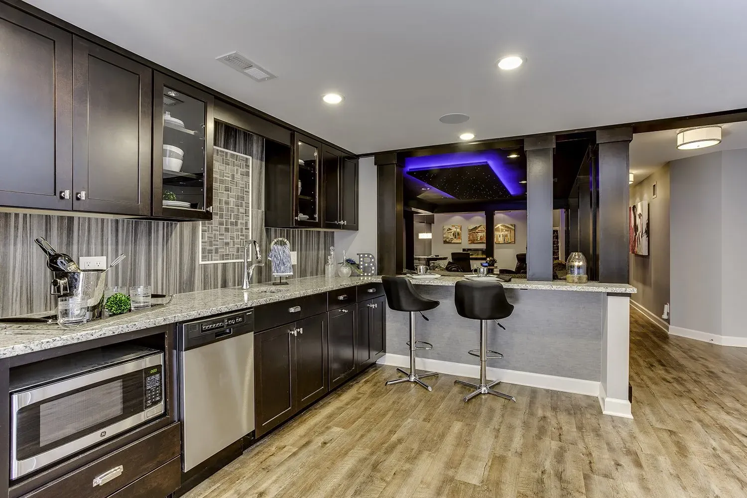 A kitchen with stainless steel appliances and wooden floors.