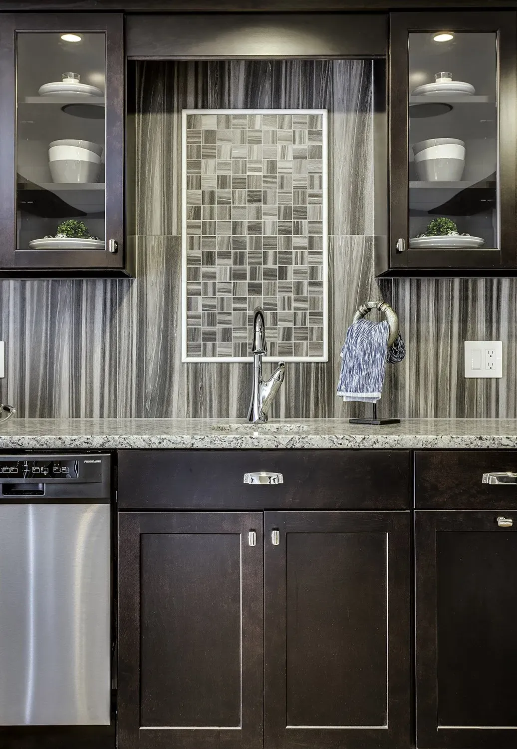 A kitchen with a sink and a stainless steel dishwasher