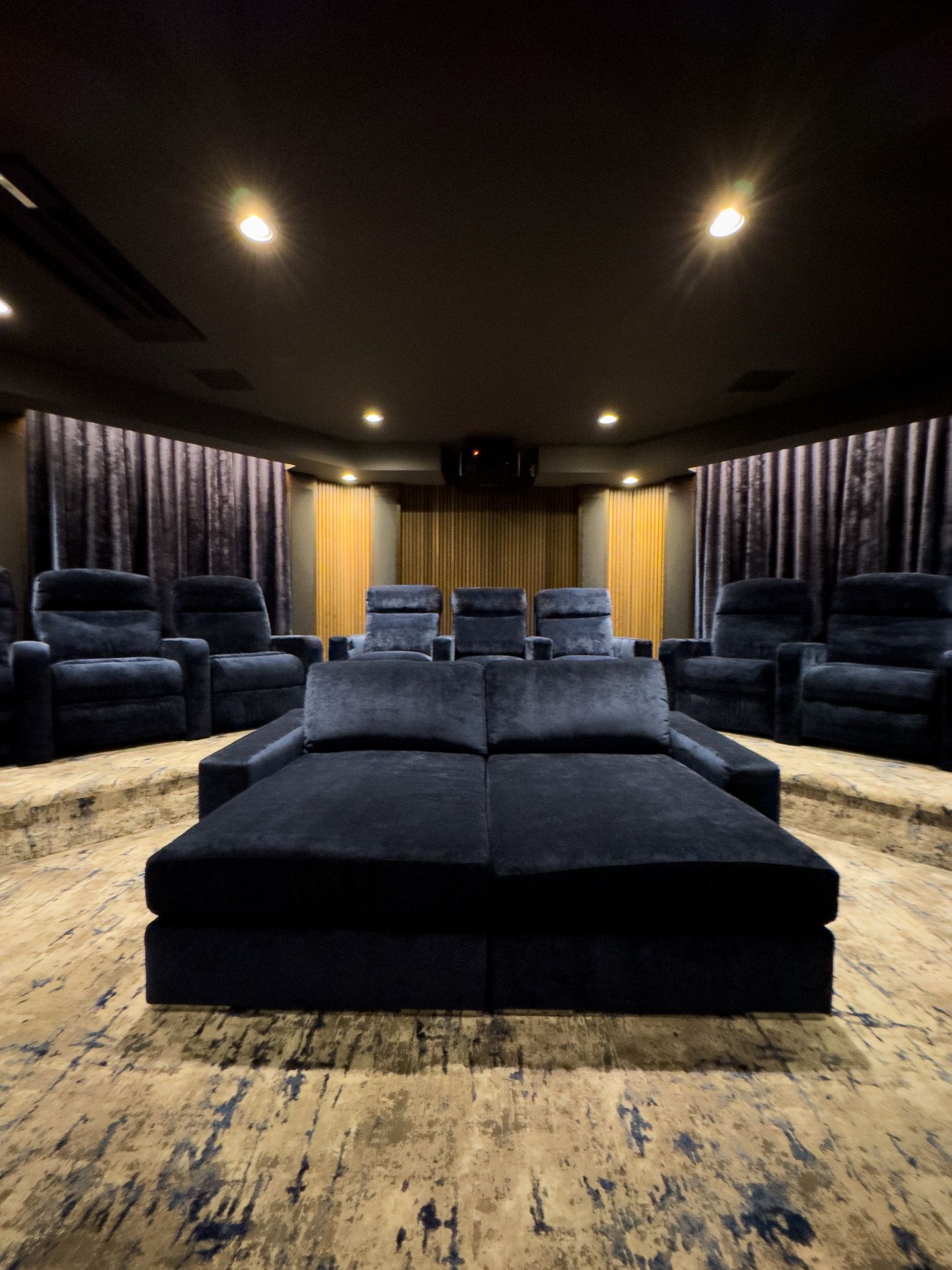 A home theater with a couch and chairs in it.