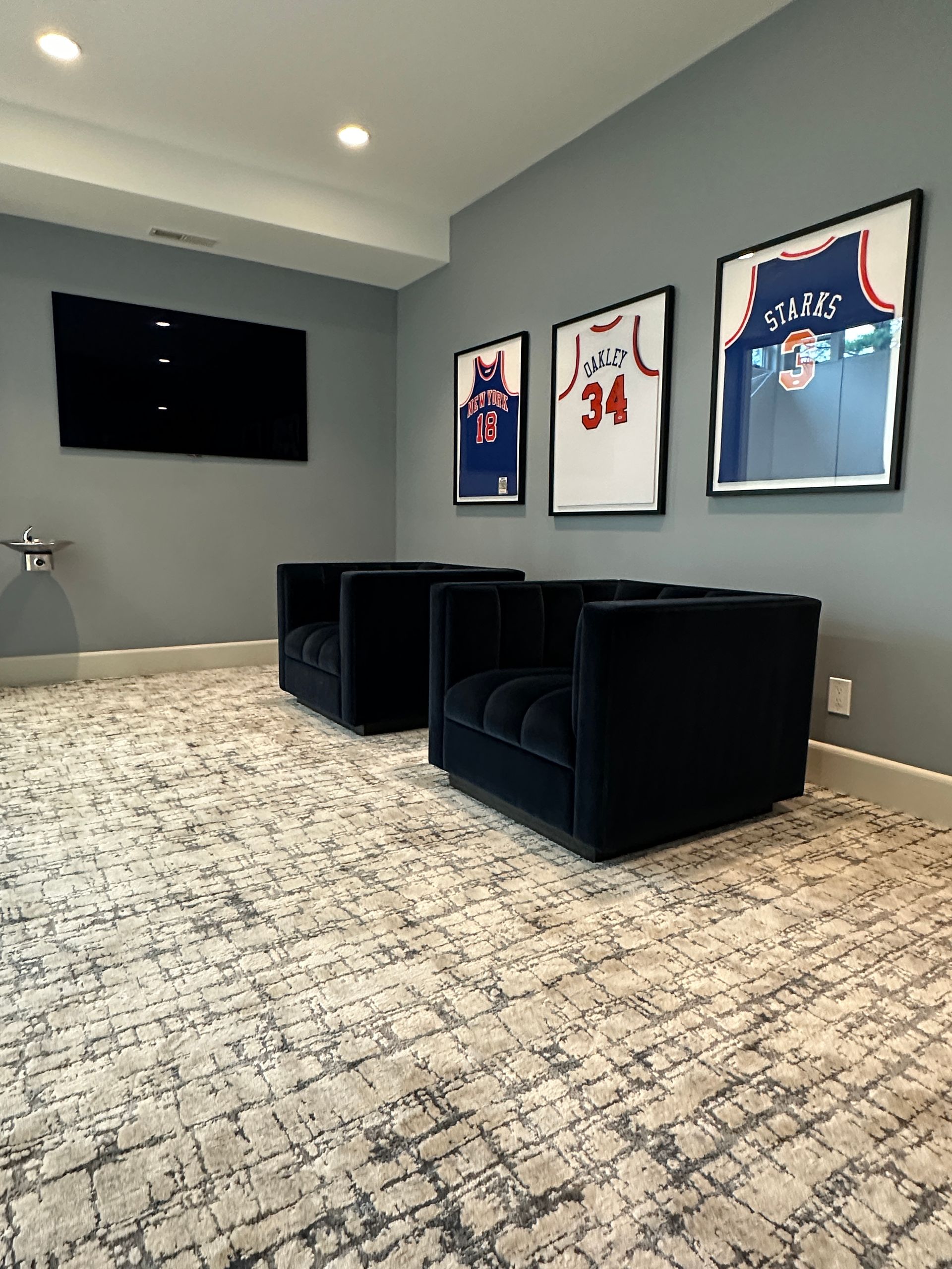 There are three basketball jerseys on the wall in this room.