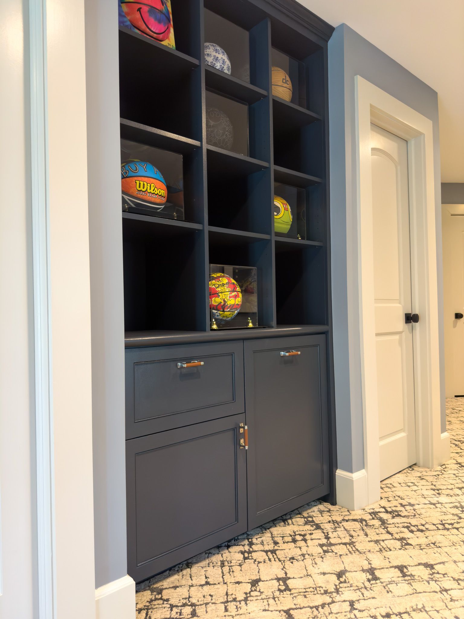 There are many basketballs on the shelves in this room.