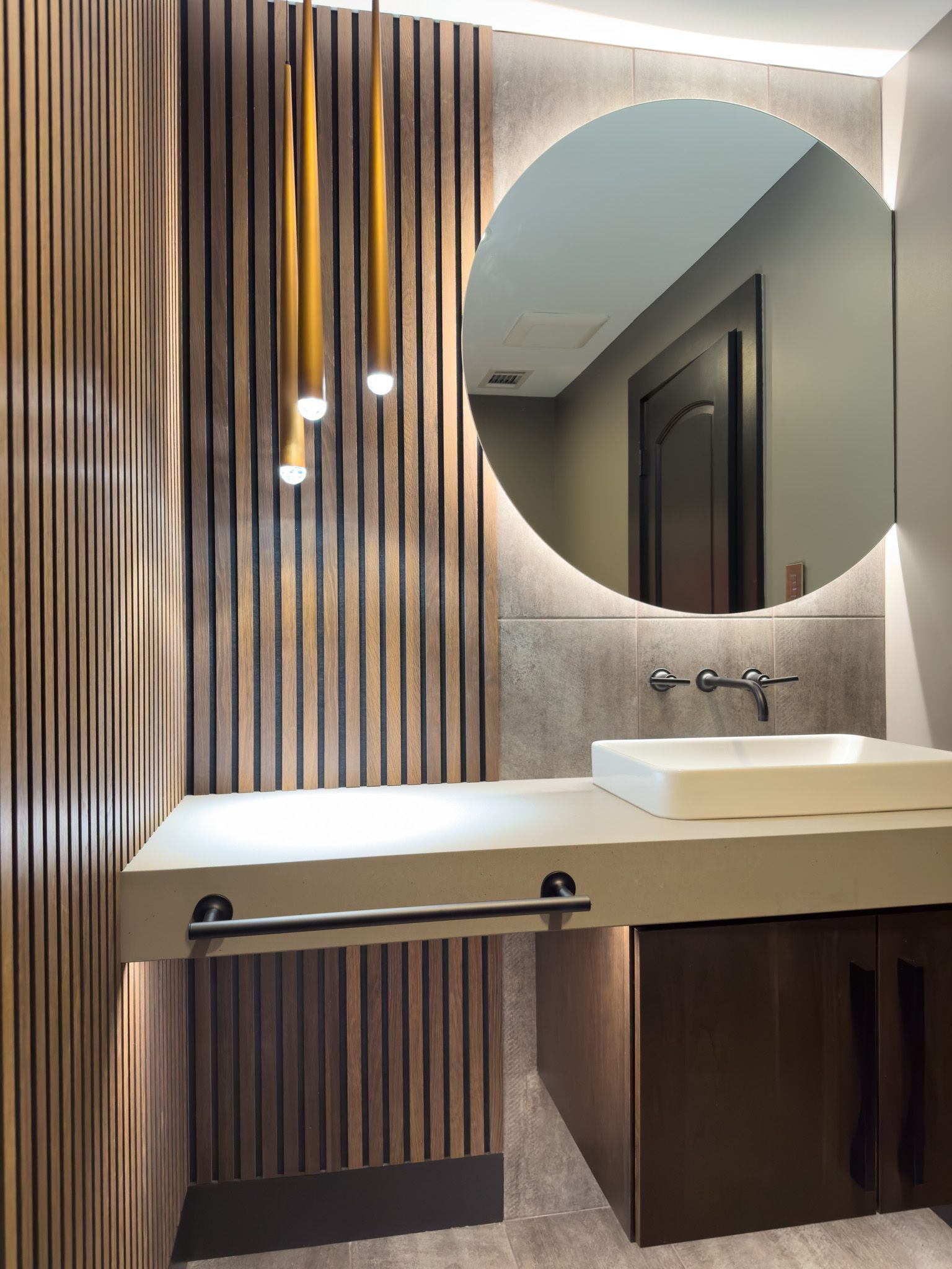 A bathroom with a sink and a round mirror