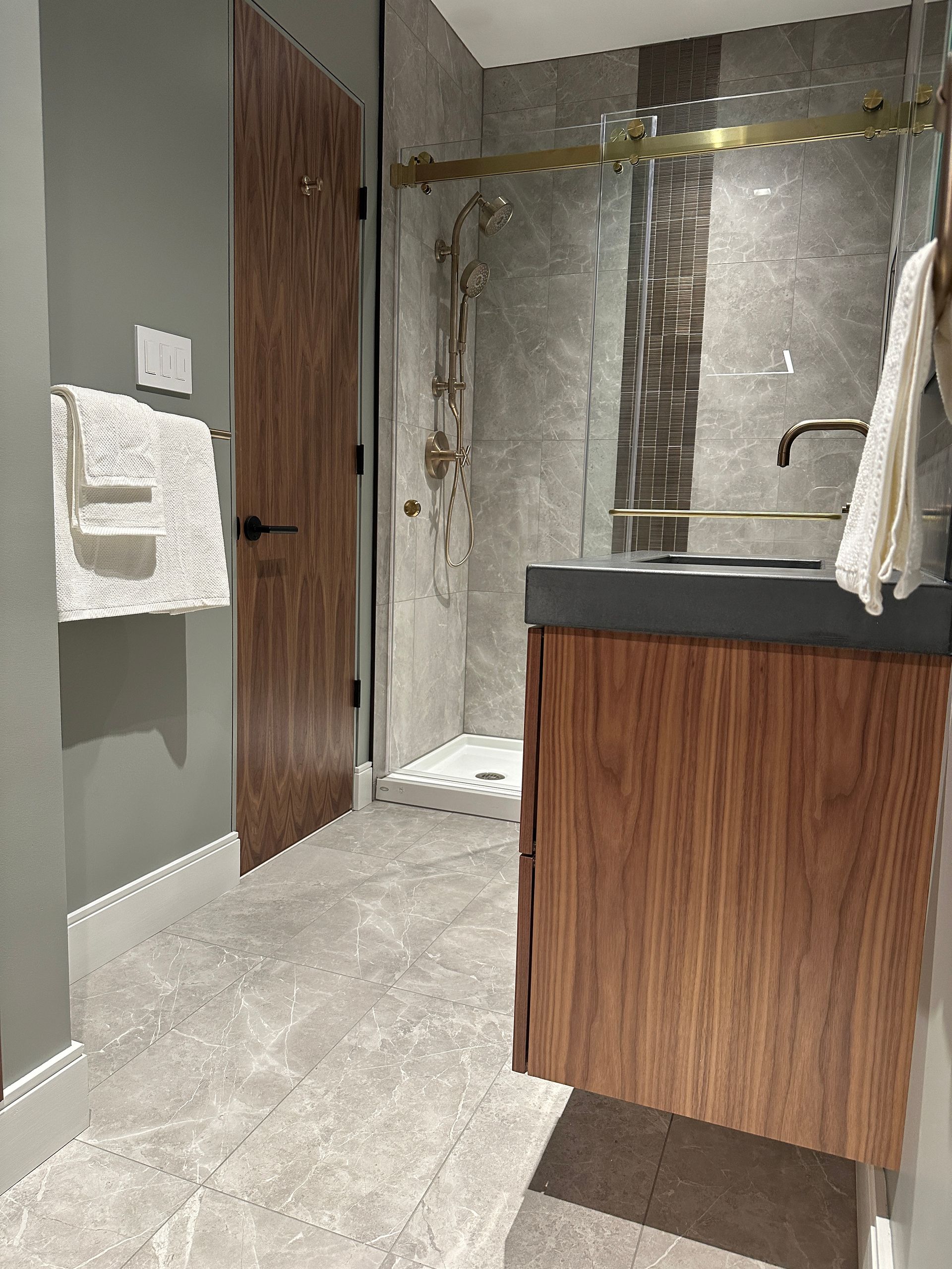 A bathroom with a sink and a walk in shower.