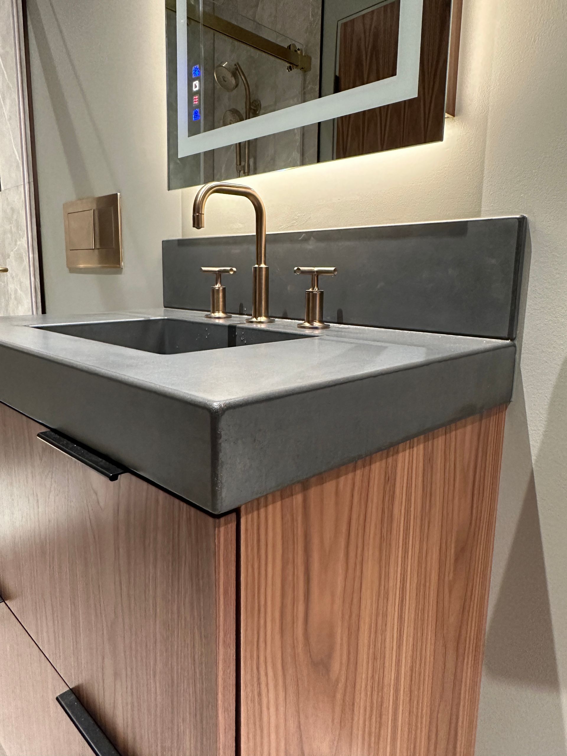 A bathroom sink with a mirror above it and a wooden cabinet.