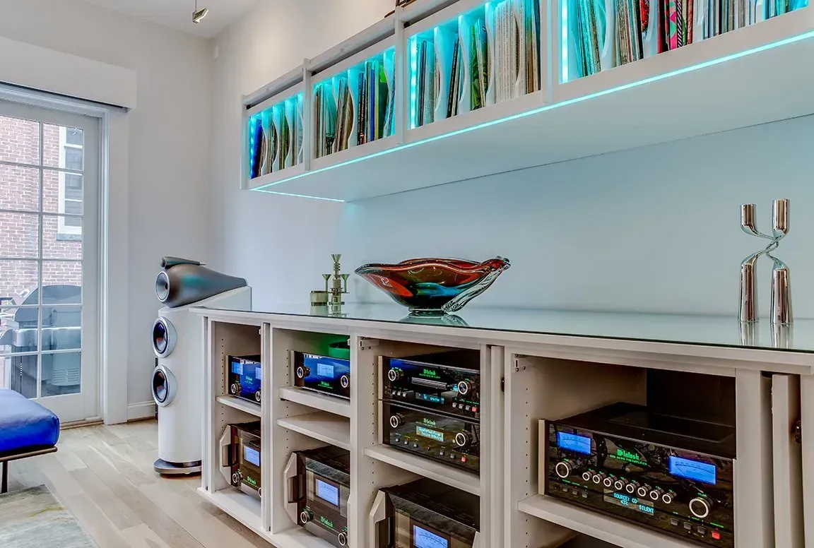 A living room filled with lots of electronics and books.