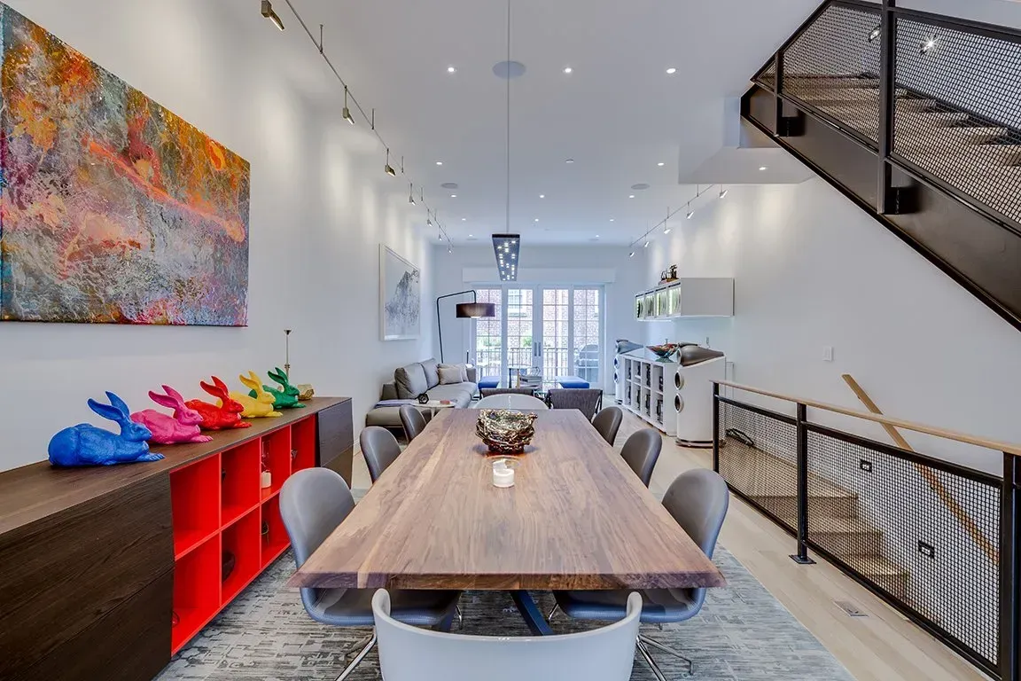 A dining room with a long wooden table and chairs.