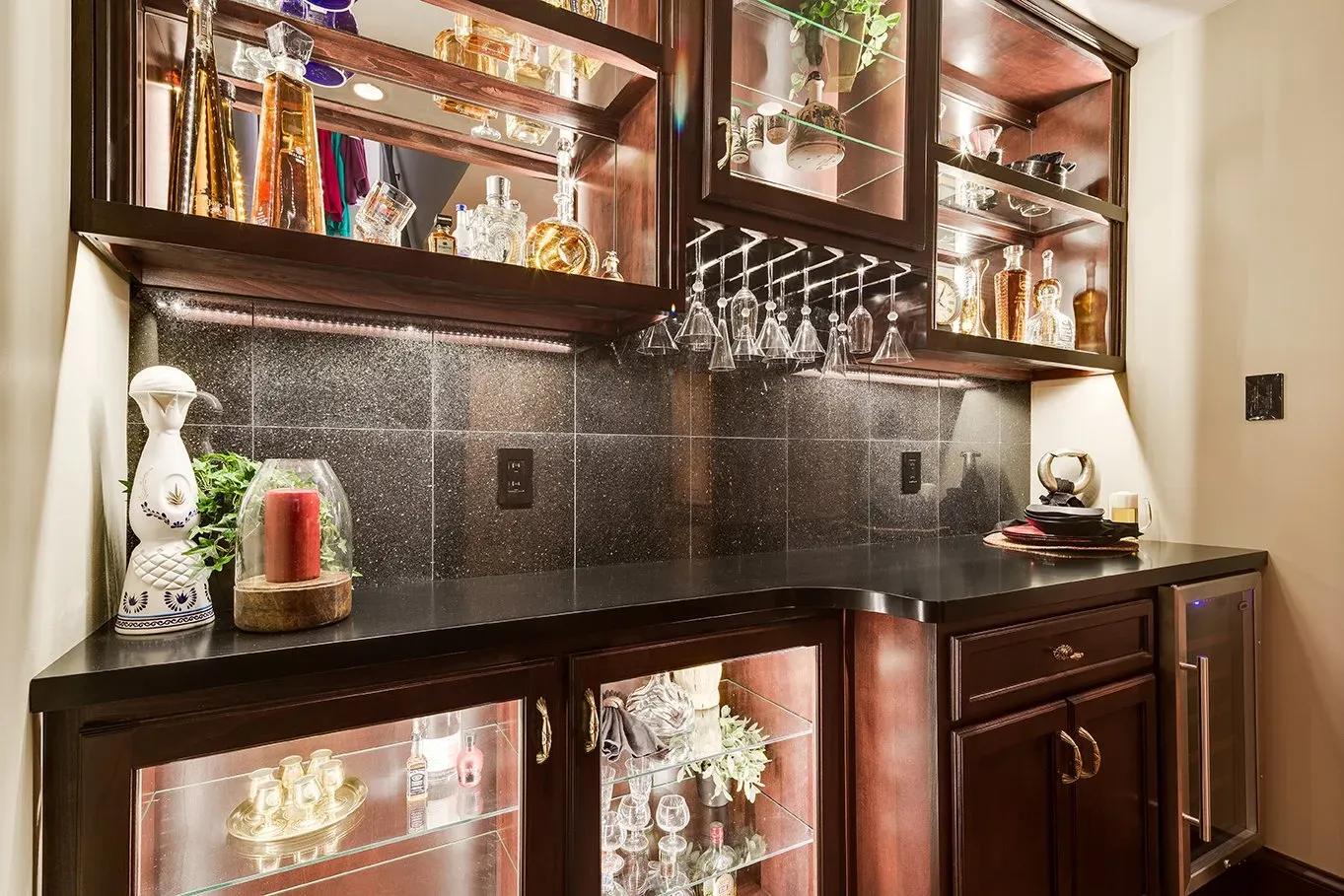A bar with wine glasses and bottles on the shelves