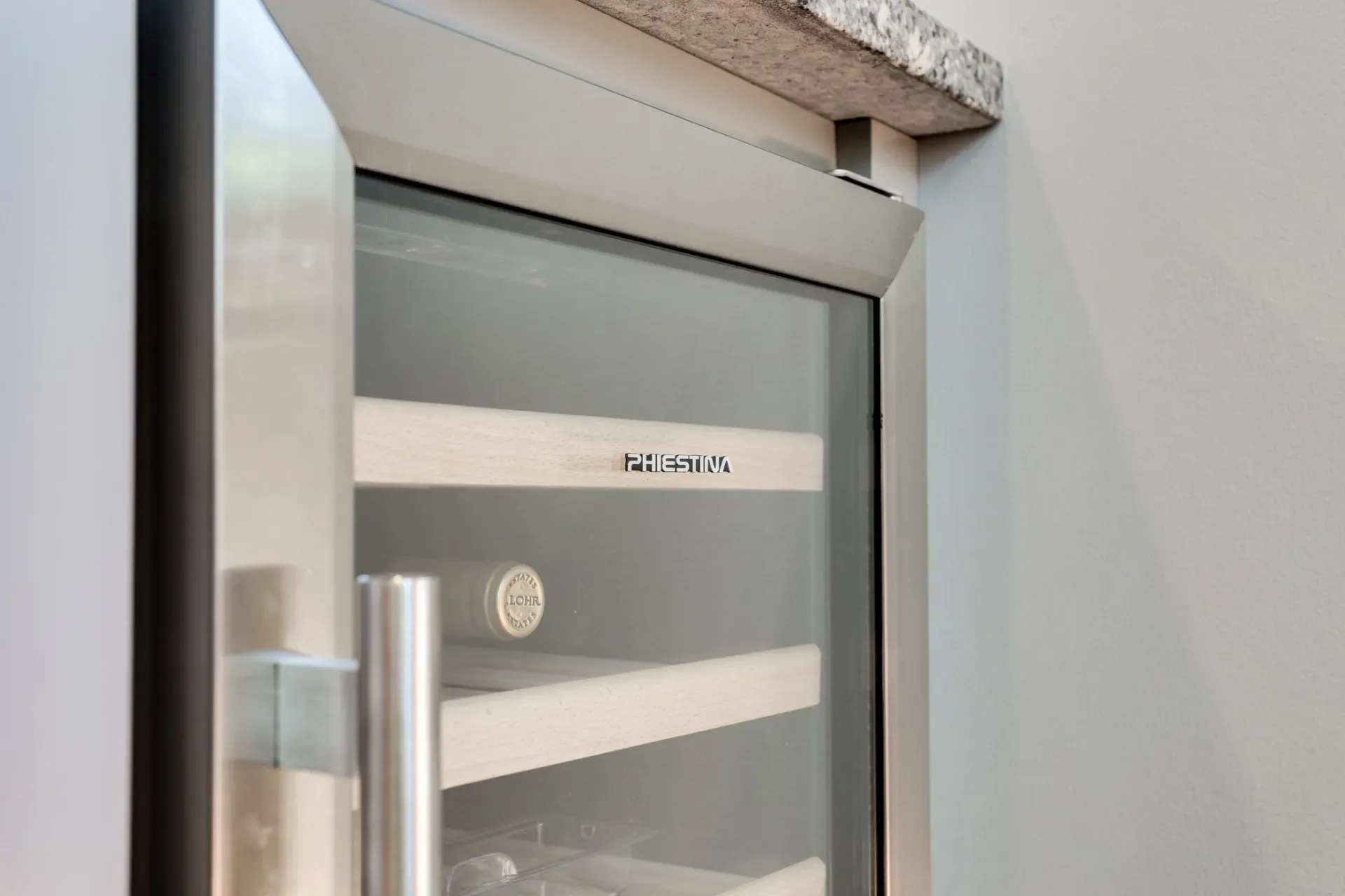 A stainless steel wine cooler with a glass door