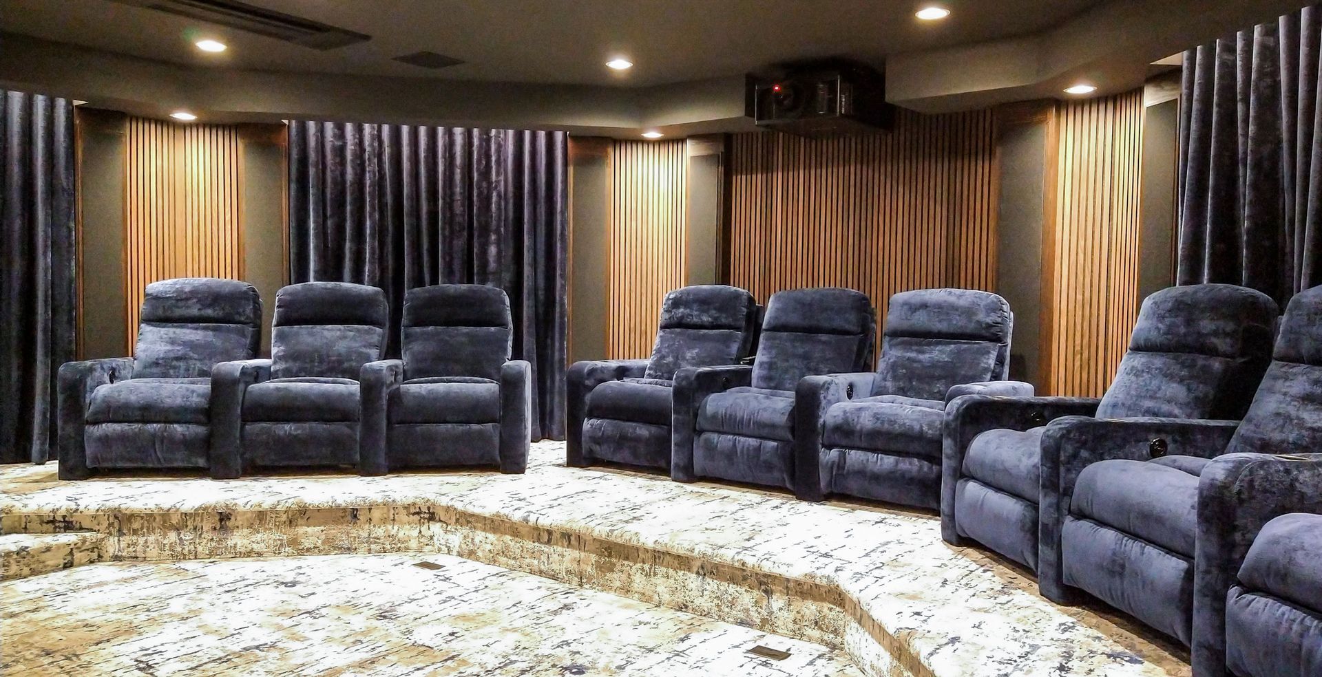 A row of blue recliner chairs in a home theater.