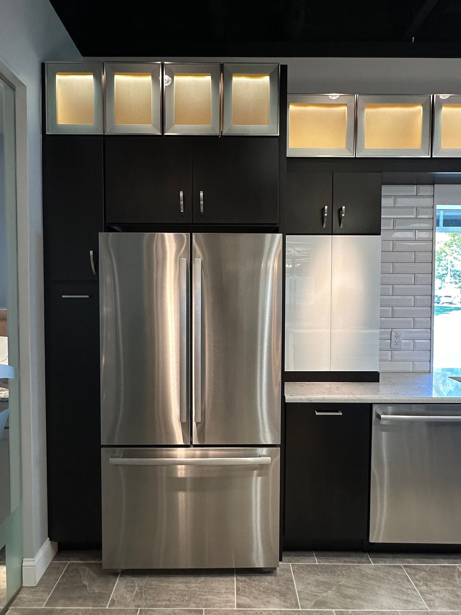 A kitchen with stainless steel appliances and black cabinets