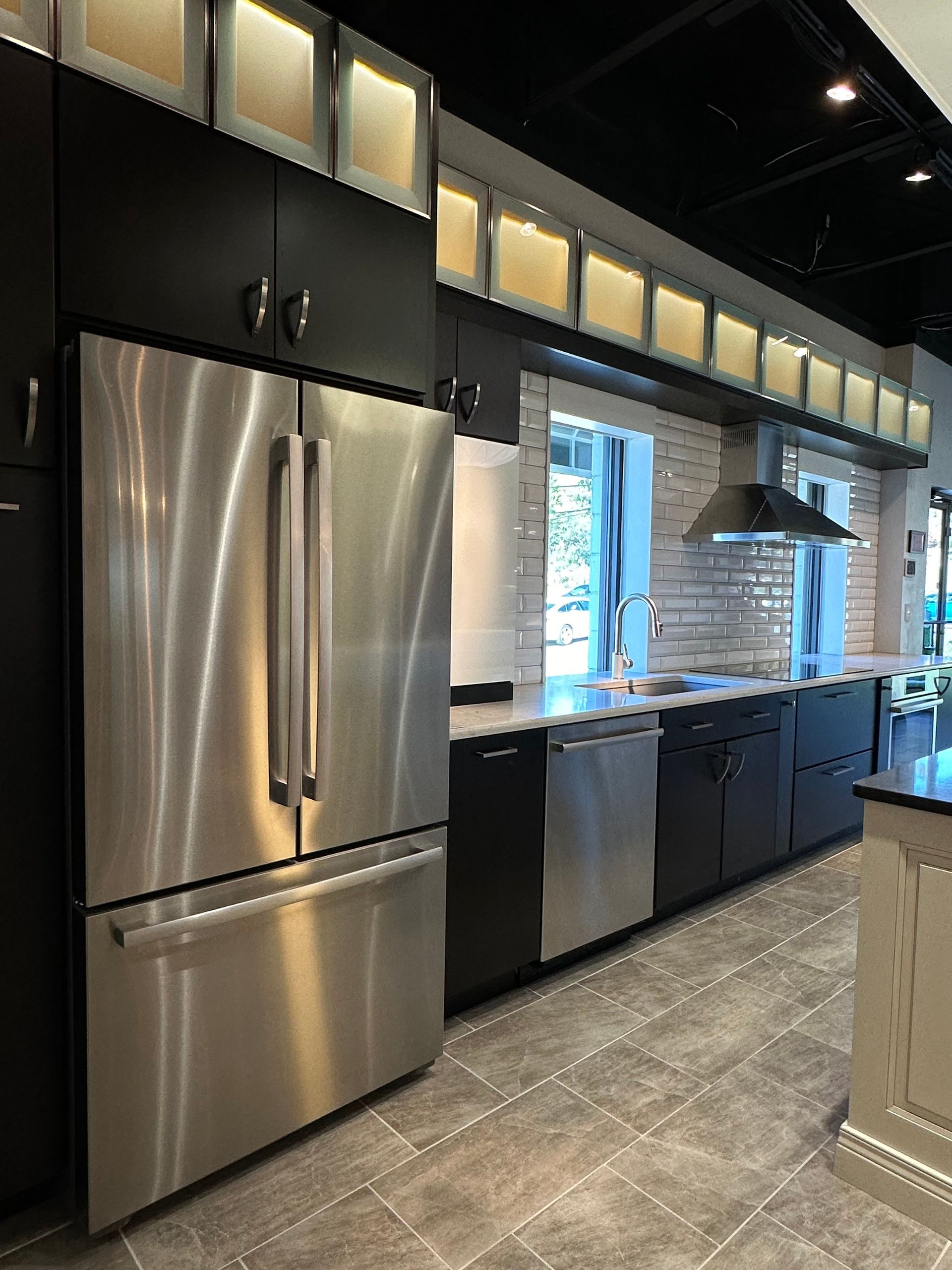 A kitchen with stainless steel appliances and black cabinets